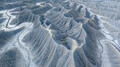 Pale Utah badlands flow in luminous silver-gray waves across the desert.