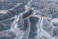 Gray shale ridges and winding erosion channels in Utah badlands.