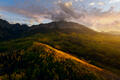 Golden Colorado aspens glow beneath a towering Rocky Mountain peak at sunset.
