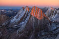 Alpenglow illuminates jagged Colorado peaks at sunrise in the Rocky Mountains.