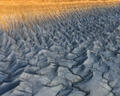 Fluted blue-gray badlands sweep beneath a glowing golden desert rim in Utah.