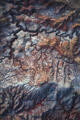 Abstract aerial view of multicolored marbled badlands in Utah desert.