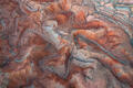 Interwoven mineral channels carve through Utah’s painted badlands in a richly textured aerial composition.