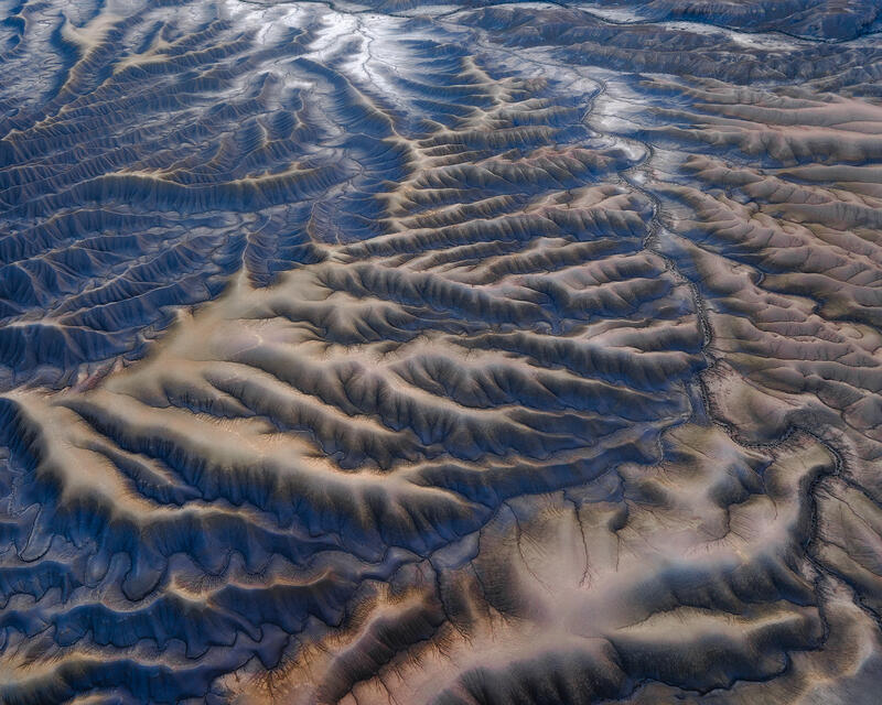 Blue-gray shale ridges in Utah badlands aerial landscape.