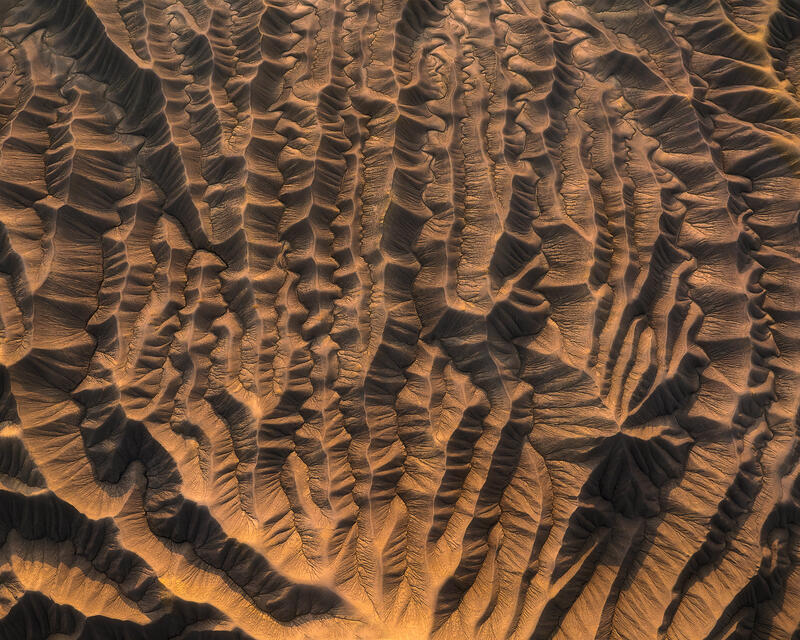 Delicate gray badland ridges branch across Utah’s desert in a quiet, minimalist aerial composition.