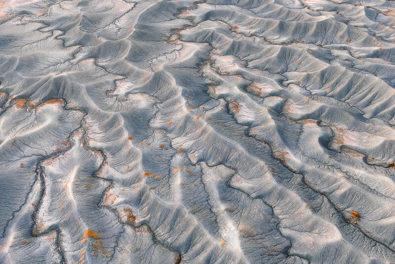 Blue-gray desert ripples flow across Utah’s sculpted badlands.