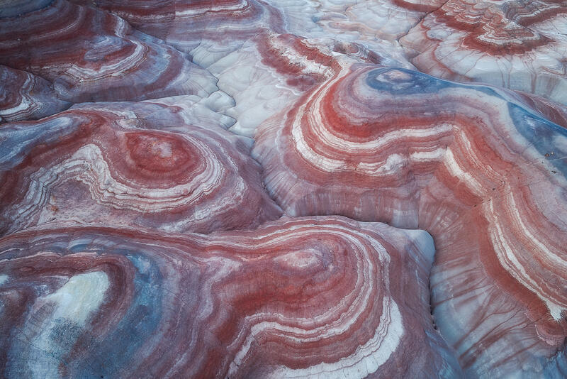 Swirling red, white, and blue patterns flow across Utah’s desert landscape.