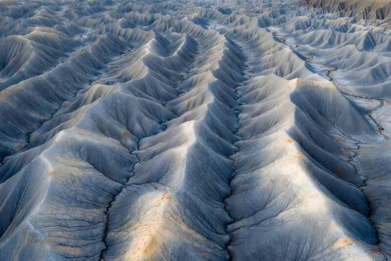Endless blue ridges form rhythmic, wave-like patterns across Utah’s badlands.