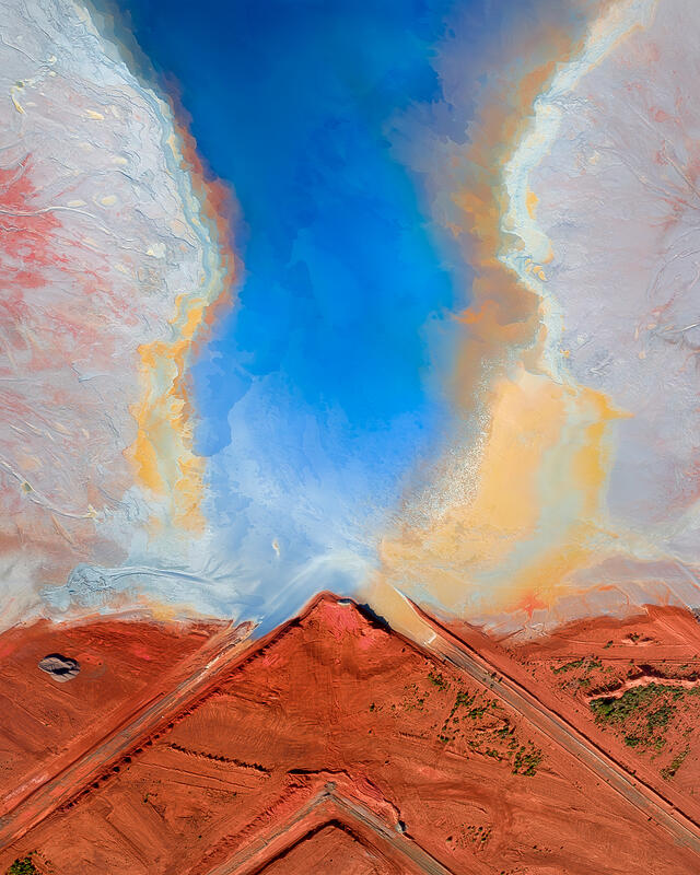 An abstract aerial composition where vivid blue water contrasts against red earth and pale mineral textures in the Australian outback.