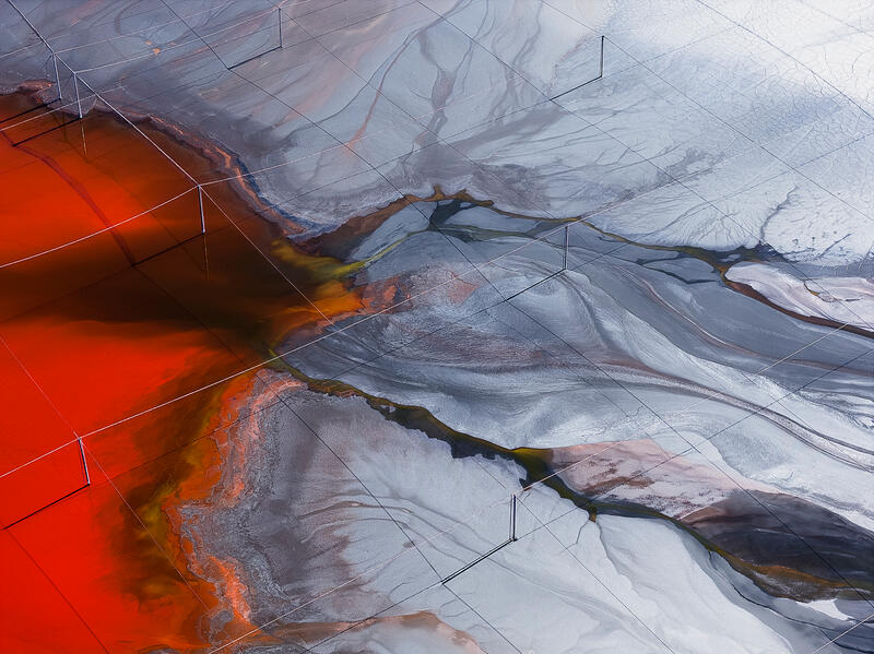 An abstract aerial of vivid mineral flows and branching textures across a dramatic Australian salt landscape.