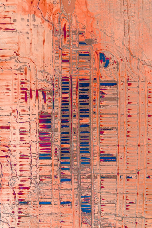 An abstract aerial of patterned earth and geometric lines resembling a vast desert circuit board.