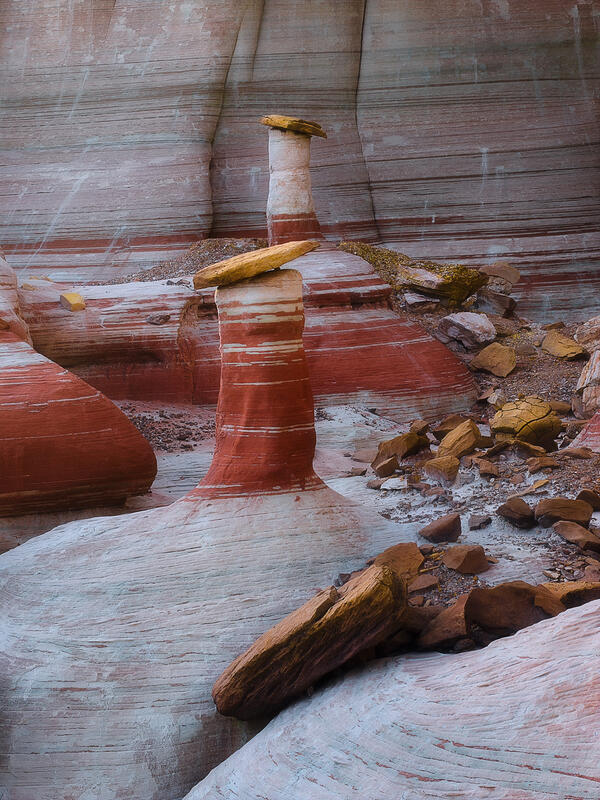 A beautifully balanced sandstone pedestal rises from softly layered desert rock, showcasing the artistry of erosion.