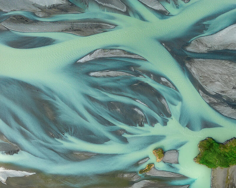 Glacial rivers weave around emerald islands, creating a luminous abstract portrait of Iceland's living landscape.
