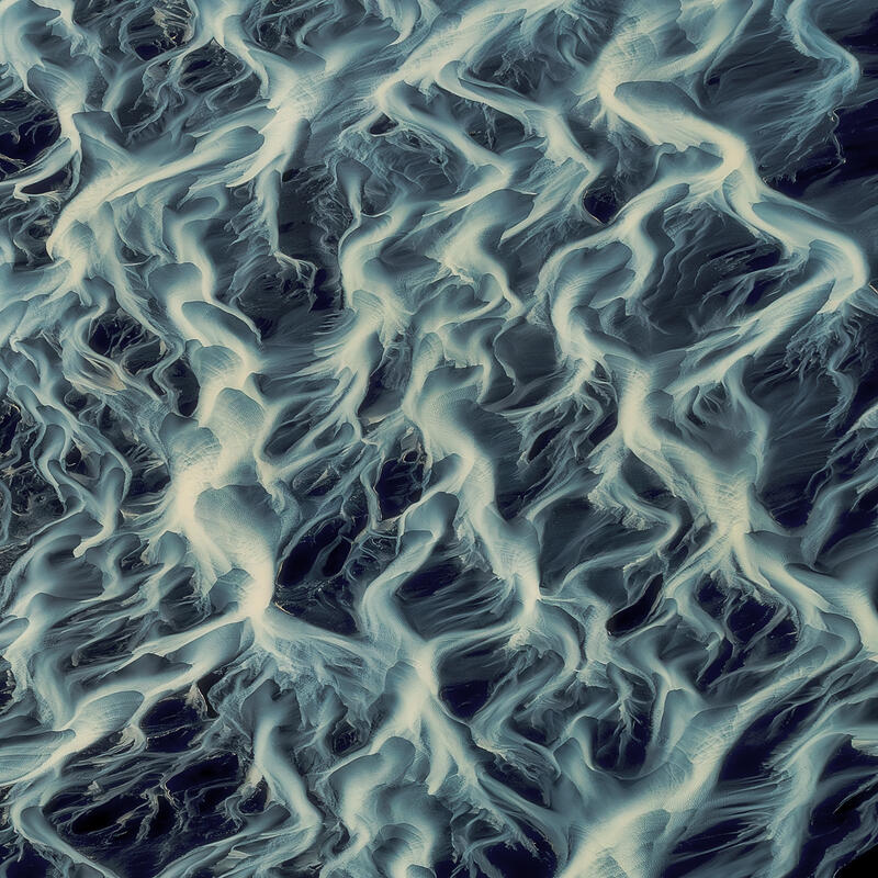 Delicate glacial channels weave together into a luminous aerial tapestry across Iceland's volcanic plains.