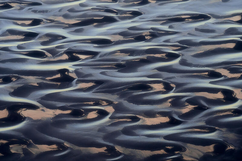 Intricate braided rivers create a woven tapestry across Iceland's volcanic landscape.
