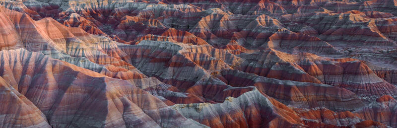 Golden light reveals the colorful rhythms and layered beauty of the Painted Desert in this intimate Southwestern landscape.