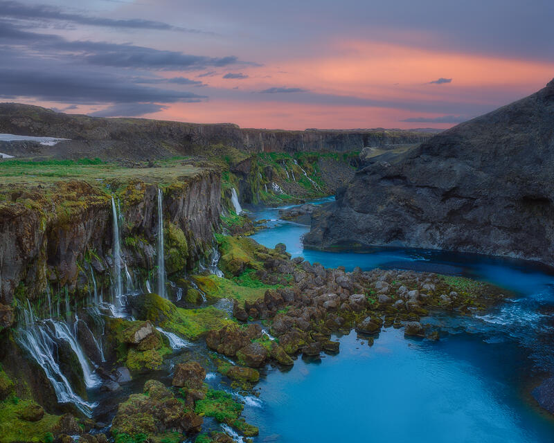 Multiple waterfalls descend into the turquoise waters of Iceland's enchanting Sigöldugljúfur Canyon.