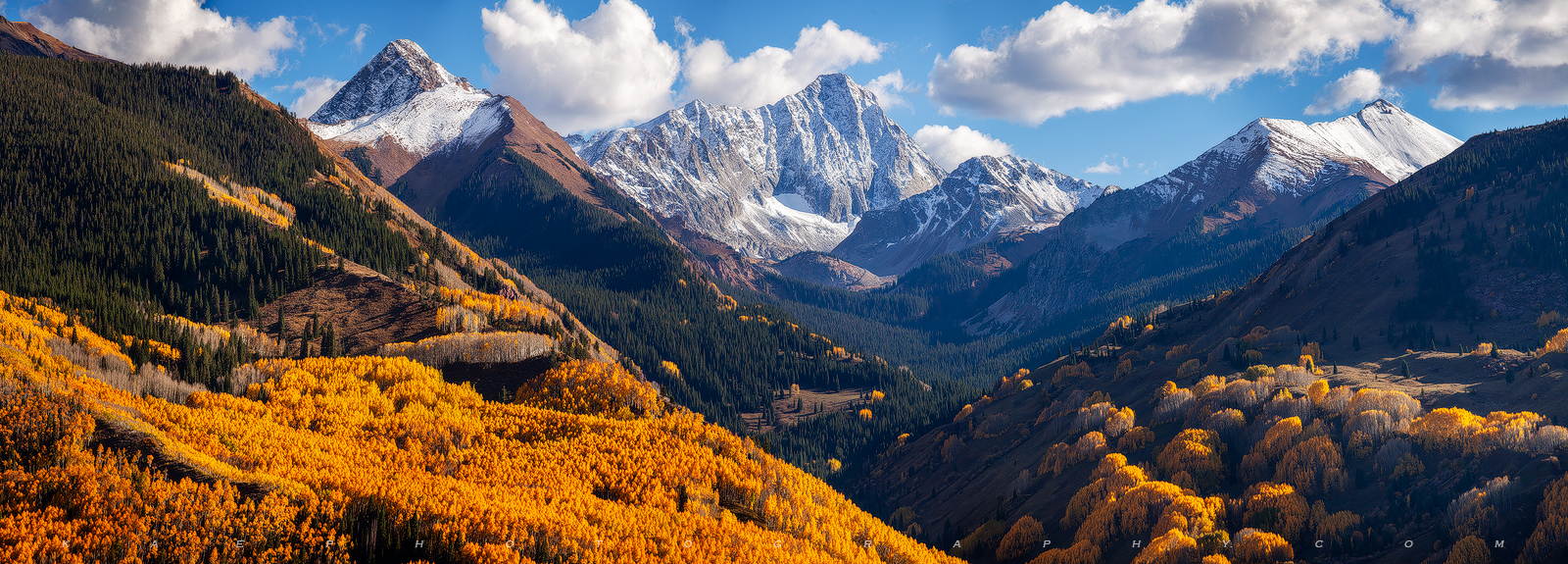 Capitol Peak & Blue Skies Panoramic | Colorado Mountain Photography Mountain is seen in the distance with red, orange, yellow trees seen in the valley and hillsides surrounding it.