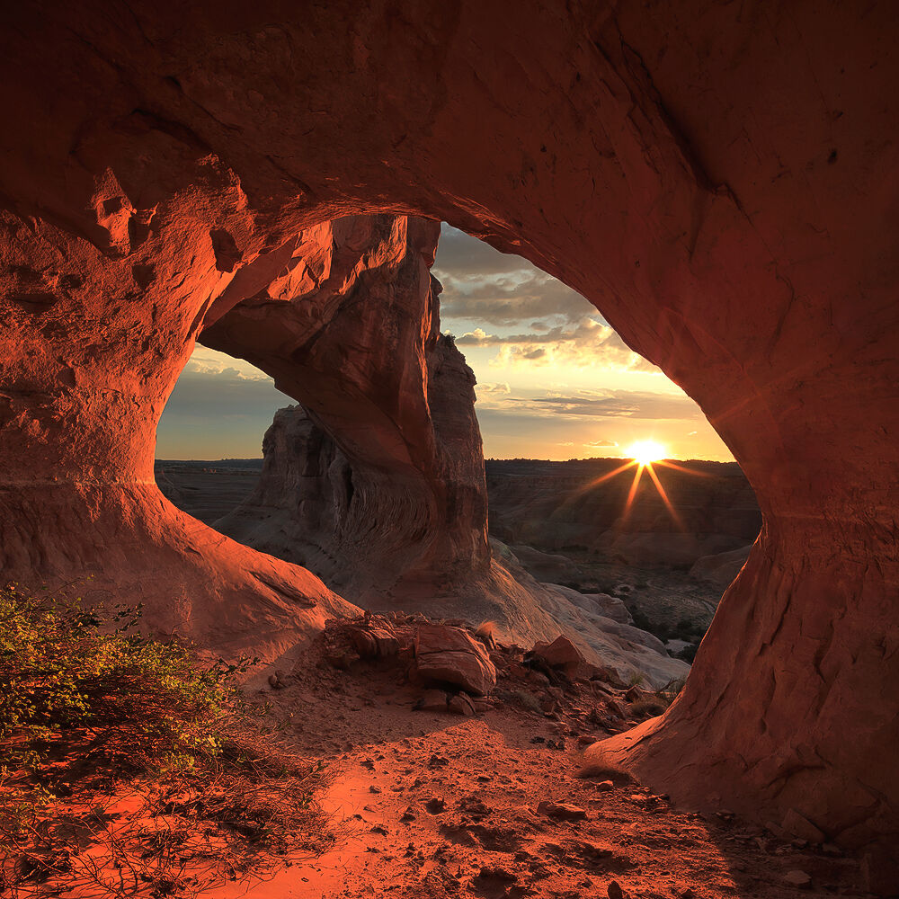 Beautiful, warm lighting makes its way into a natural alcove below a very large arch.