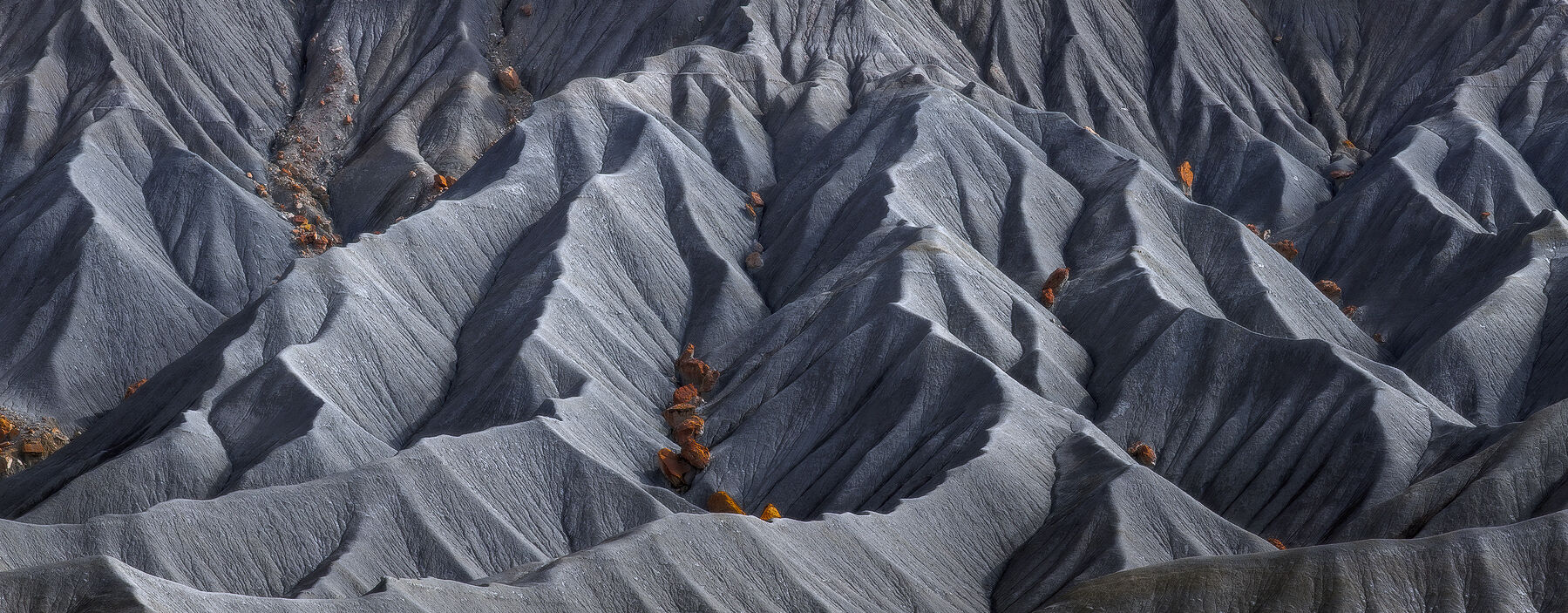 Shale rock formations have highlights bronze deposits cradled within the peaks and ridges which are viewed up close to create an abstract appearance.